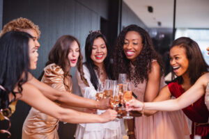 A Diverse Group Of Female Friends Toasting To The Bride-To-Be During A Bachelorette Party